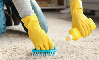 comfort a man wearing yellow household gloves as protection while handling chemicals to clean the carpet | Allgloves