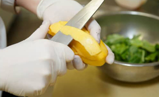 food-safe a food handler wearing a pair of white gloves while peeling fruits | Allgloves